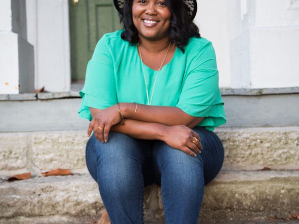 headshot of a women named Robin Robinson sitting on the steps of a front porch