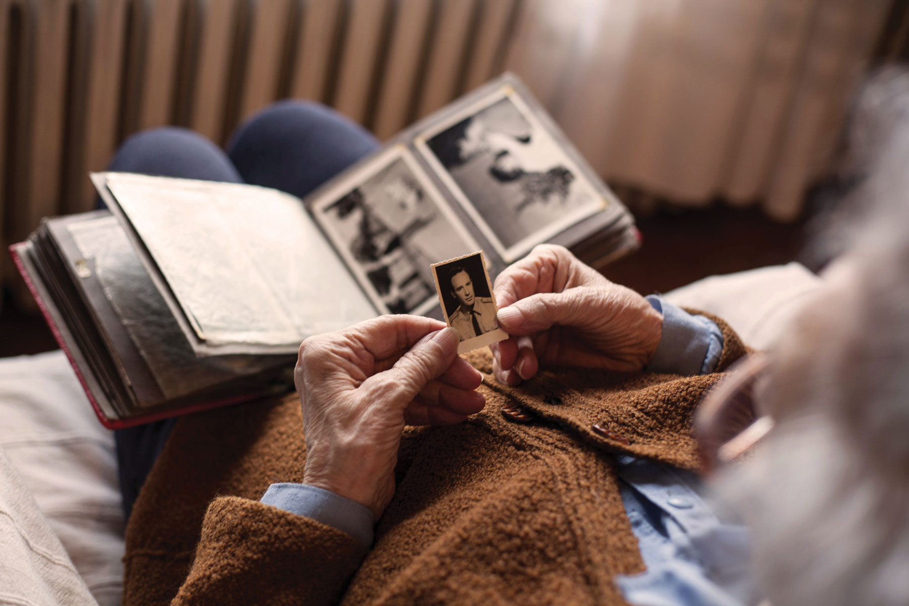 Senior Adult Holding An Old Photo In Hands