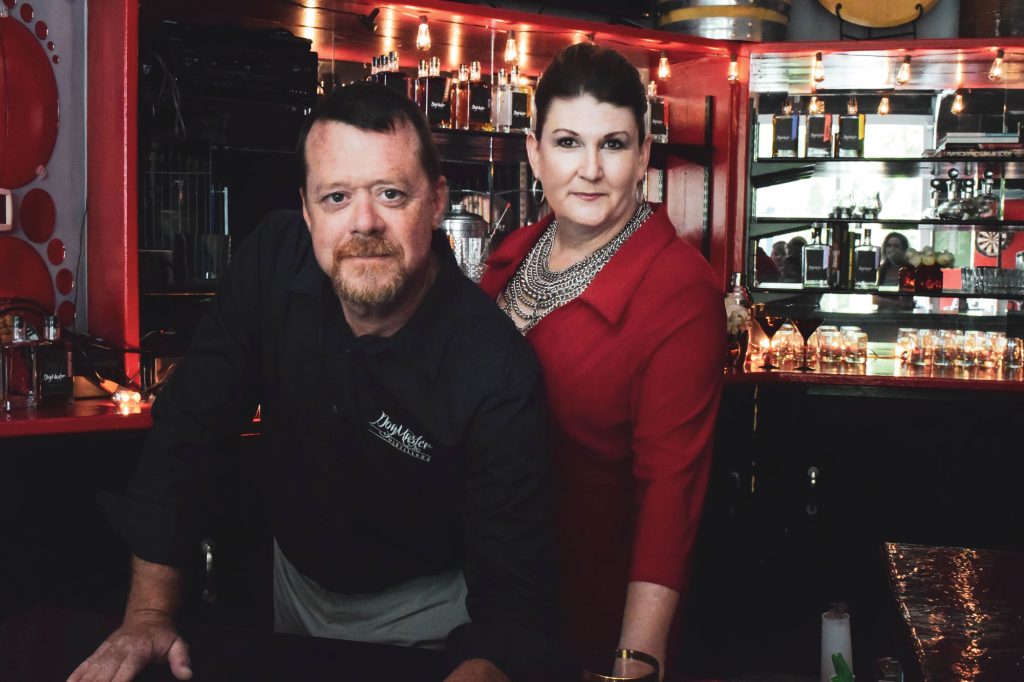 a man and a women standing behind a bar