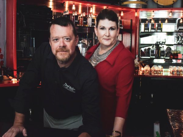 a man and a women standing behind a bar