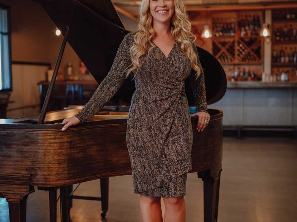 Headshot of a women named Amanda Ruyle standing in front of a piano