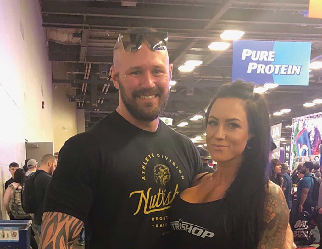 while the woman has long dark hair and tattoos