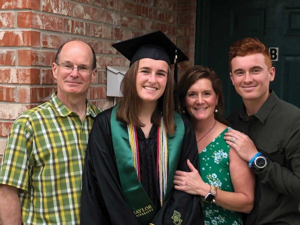 surrounded by her parents and brother.