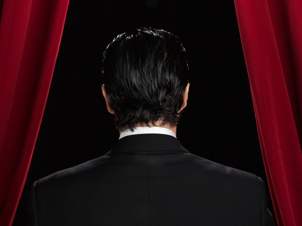Business Man Standing Behind Curtains On Stage Featured