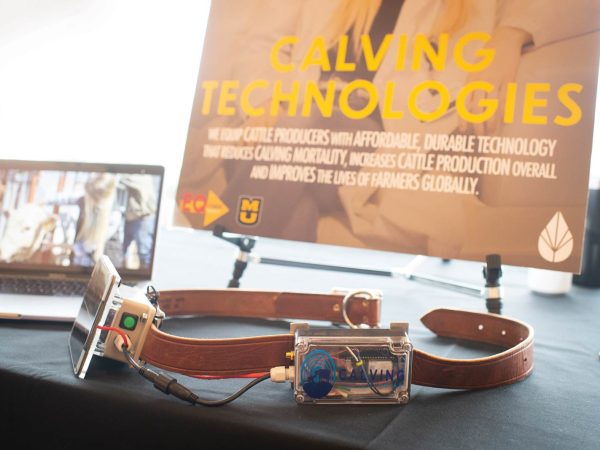 emphasizing solutions for cattle producers. A laptop with a farm-related image is also visible.