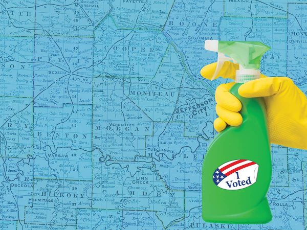 A gloved hand holds a green spray bottle with an I Voted sticker on it against a blue map background.