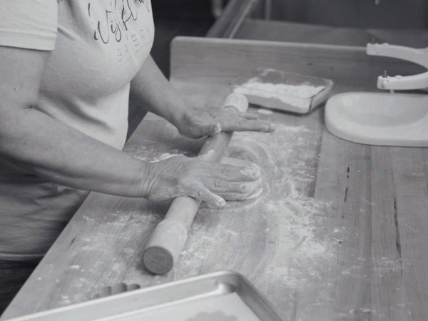como-cooks-at-kitchen-counter-rolling-dough-on-a-floured-countertop