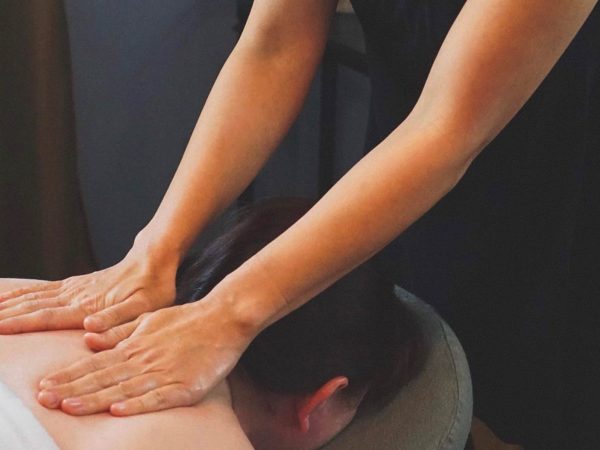 Masseuse massaging person's shoulders