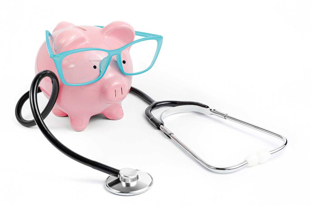 a pink piggybank wearing blue glasses with a stethoscope wrapped around the toy