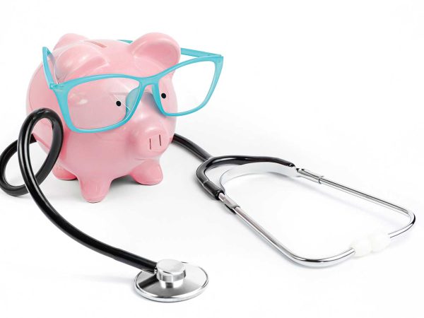 a pink piggybank wearing blue glasses with a stethoscope wrapped around the toy