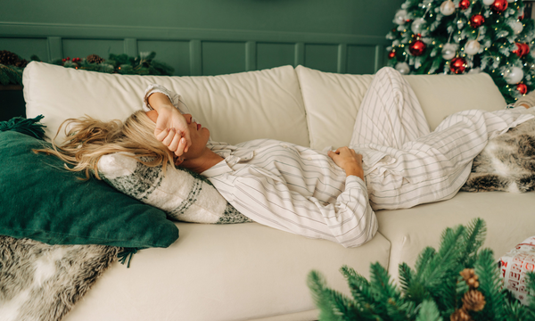 Lady lounging on Holiday couch therapy with christmas tree in the background