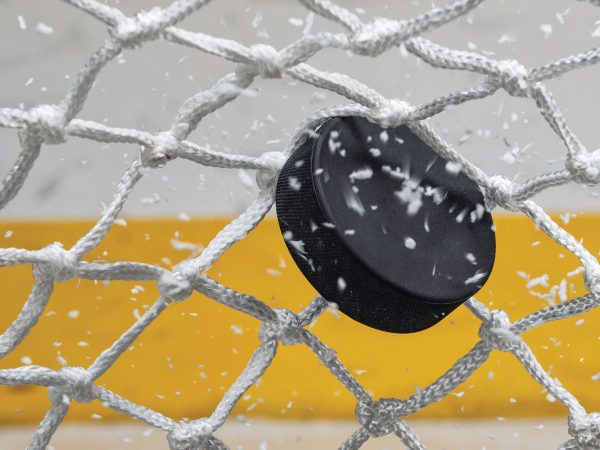 Ice hockey puck hitting the net