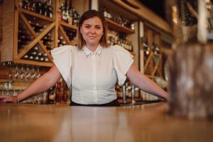Headshot of a women named Kerri Roberts standing behind the bar counter