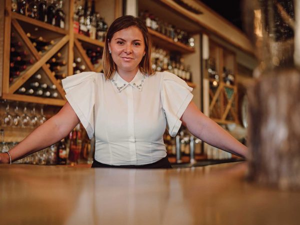 Headshot of a women named Kerri Roberts standing behind the bar counter