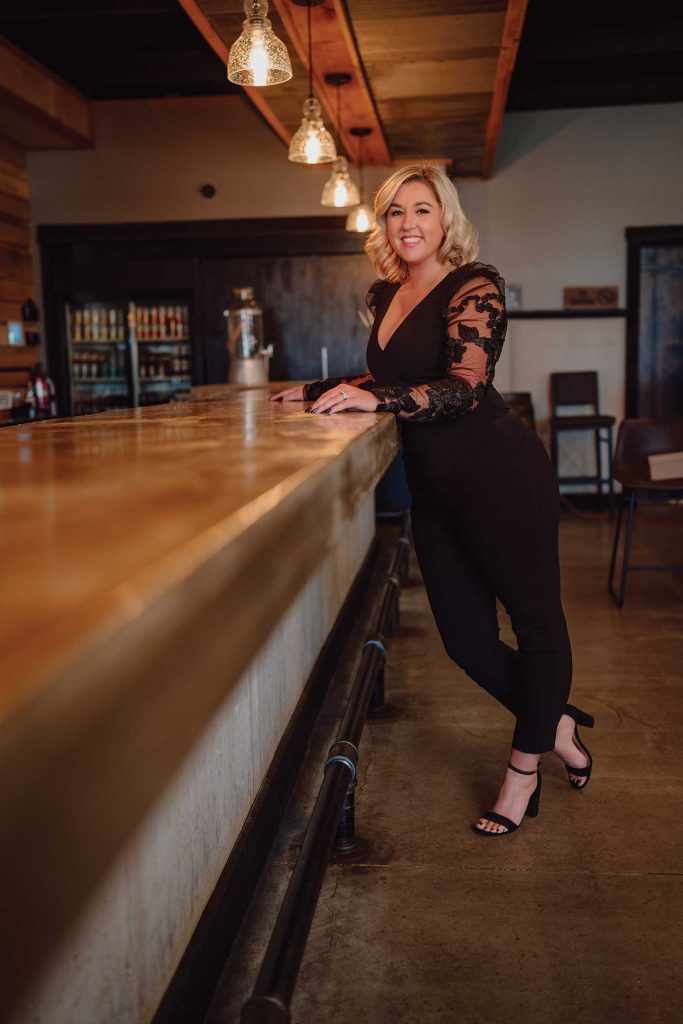 Headshot of a women named Lauren Karr standing by a bartop counter
