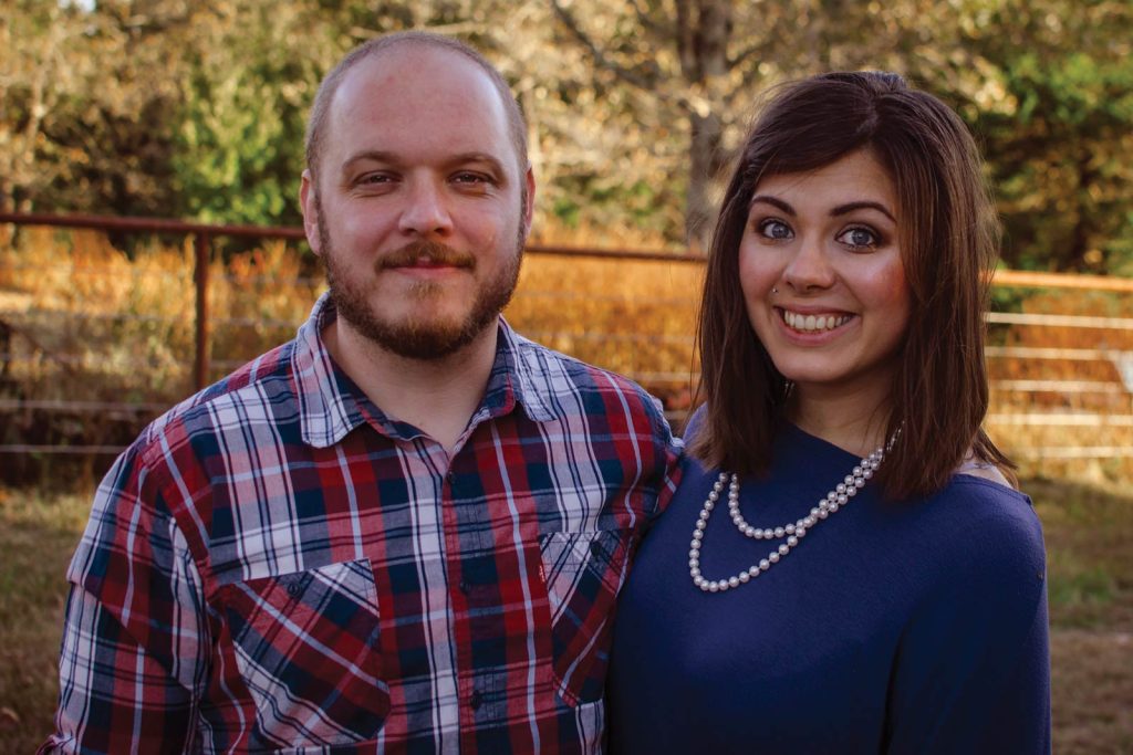 embracing each other. The man wears a red and blue plaid shirt