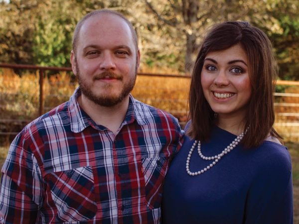 embracing each other. The man wears a red and blue plaid shirt