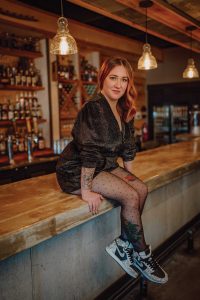 Headshot of a women named Misty Larkins sitting on a bar counter top
