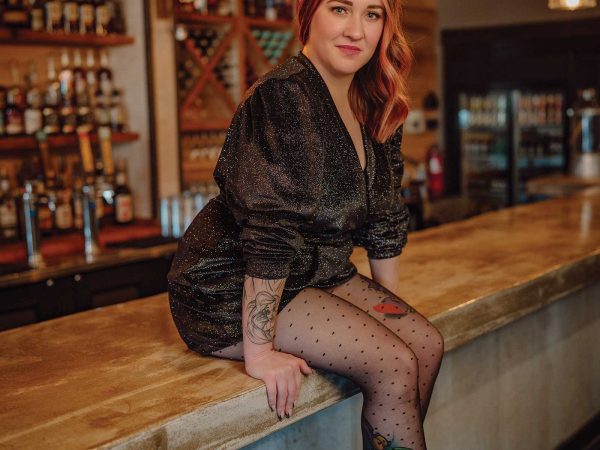 Headshot of a women named Misty Larkins sitting on a bar counter top