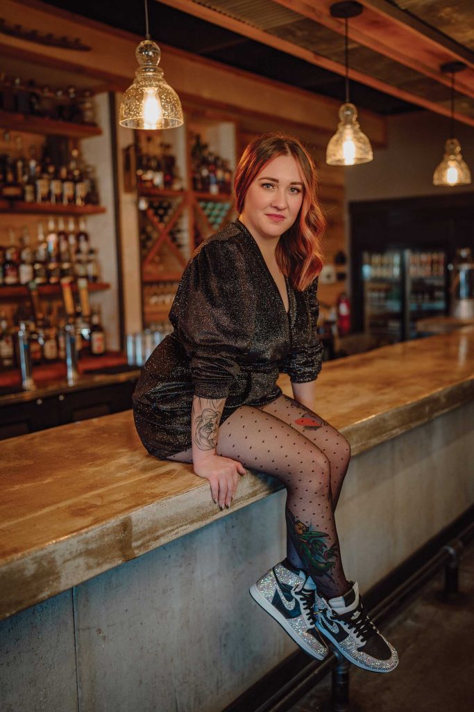 Headshot of a women named Misty Larkins sitting on a bar counter top