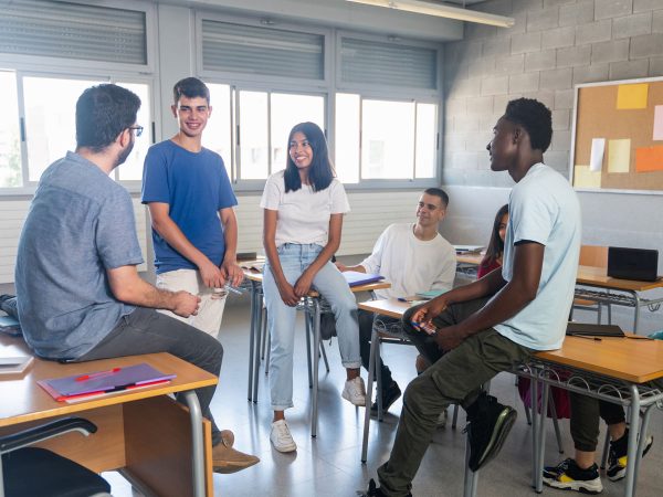Students and teacher having a conversation at classroom