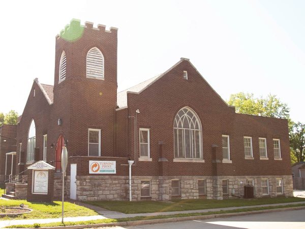 illuminating the building. The church is surrounded by grass and trees
