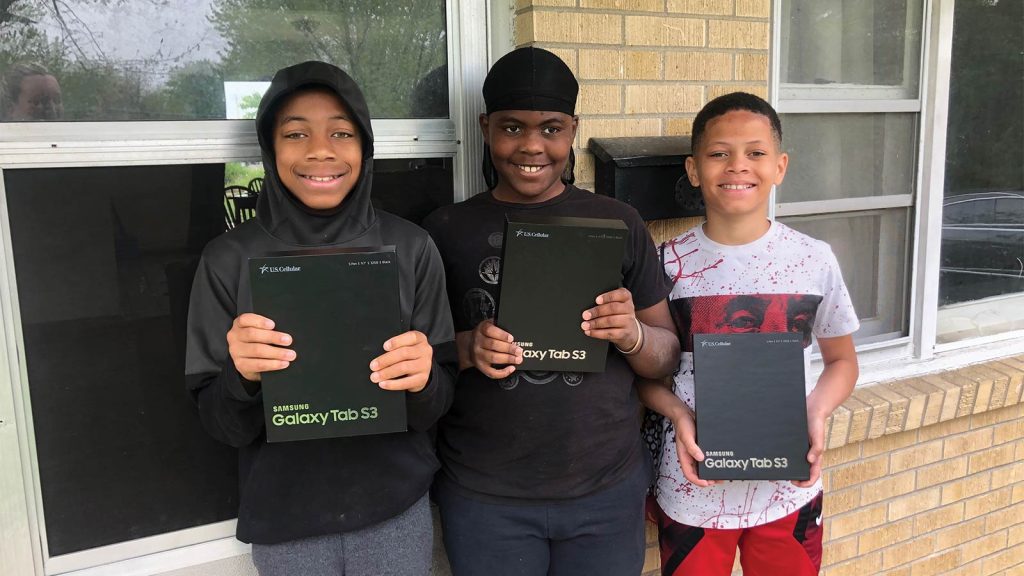 each holding a Samsung Galaxy Tab S3. They smile at the camera