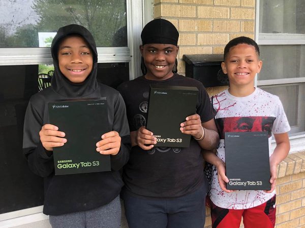 each holding a Samsung Galaxy Tab S3. They smile at the camera