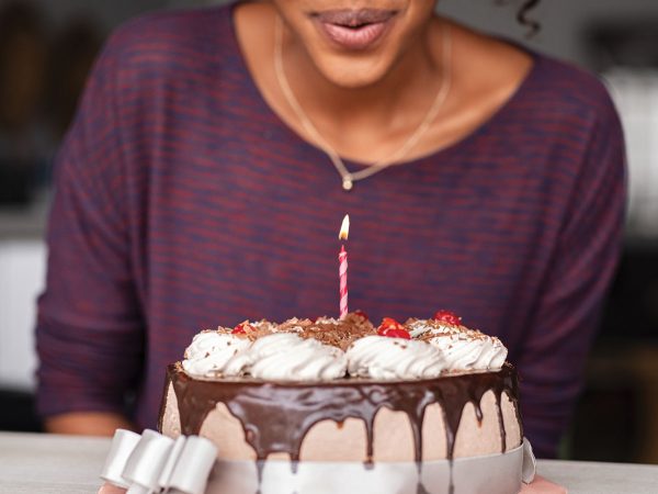 Woman blowing out candle on birthday cake