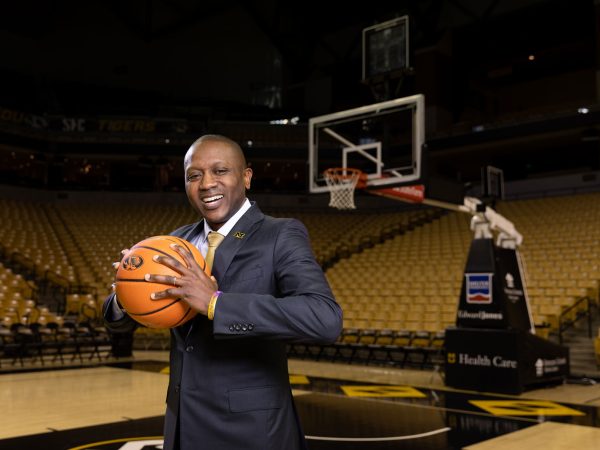 Mizzou basketball coach holding a basketball on the basketball court|headshot of Dennis Gates