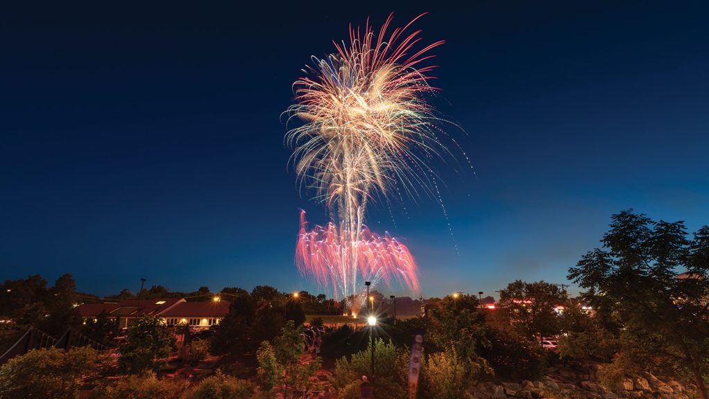 colorful fireworks illuminate the area.|view of a lush flower bed in front of a field where six columns stand in front of a large dome building called "Jesse Hall"|view of a plate of cooked meat served with vegetables|view of a walking trail featuring a wood and metal bridge surrounded by thick forest|view of a large tree on the side of a road surrounded by a field at dusk|close up shot of a platter of six fresh tacos served with lime wedges and a cup of sauce from Carlitos tacos|view of a gold course with a speckling of trees dotting the pristine landscape and a group of golfers standing in the distance|Fisheye lens view of a packed crowd of people at Faurot football field at sunset with a vibrant pink
