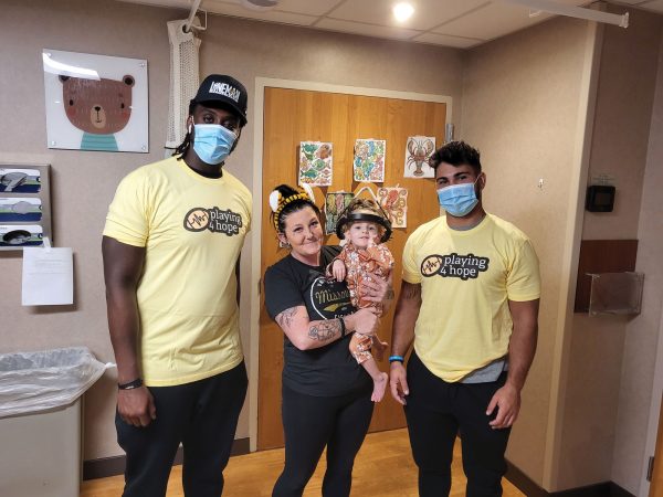 Playing-4-Hope-volunteers-flanking-mom-and-kiddo-in-hospital-room