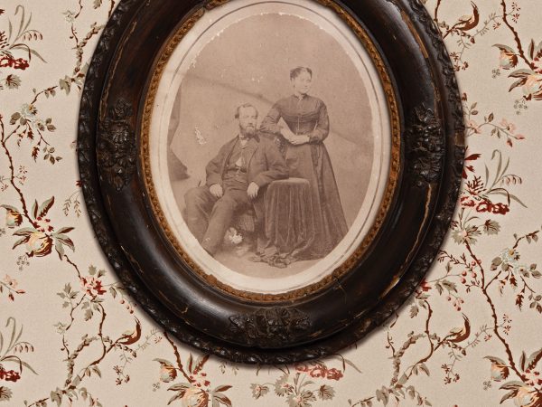 Portrait-of-Sanford-and-Kate-Conley-in-Oval-vintage-frame-hanging-on-floral-wallpaper