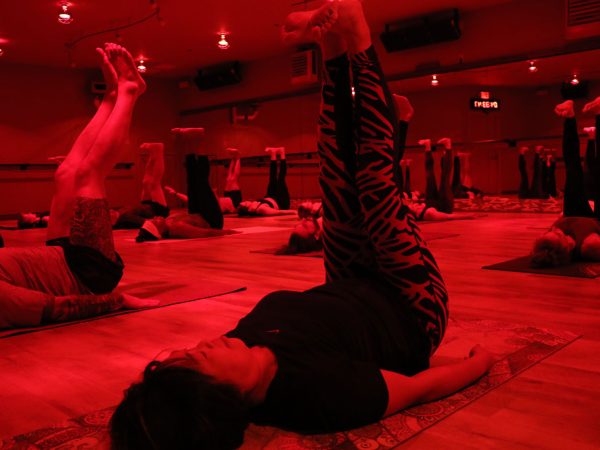 Sauna-Yoga-under-heat-lamps-participants-feet-in-the-air