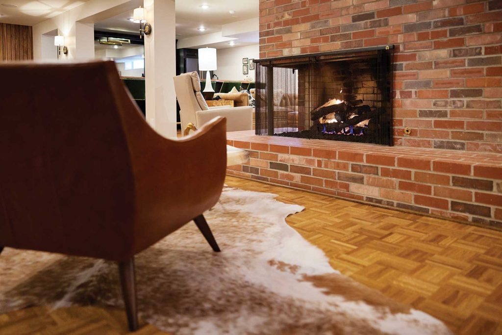 and part of a brown chair and a fur rug are visible in the background.|columbia basement house|columbia basement|A spacious basement with exposed wooden beams and unfinished concrete walls. The floor has colorful chalk outlines. Exercise equipment