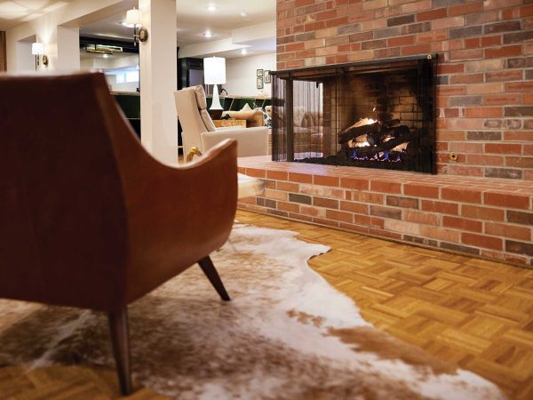 and part of a brown chair and a fur rug are visible in the background.|columbia basement house|columbia basement|A spacious basement with exposed wooden beams and unfinished concrete walls. The floor has colorful chalk outlines. Exercise equipment