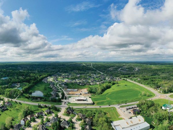 surrounded by trees and fields. The sky is partly cloudy