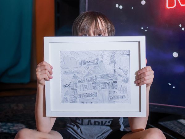 featured-charlie-bittle-holding-his-artwork-on-stage-at-cafe-berlin