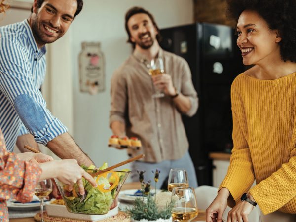 Friend Group Of Adult Couples Cooking Dinner Together