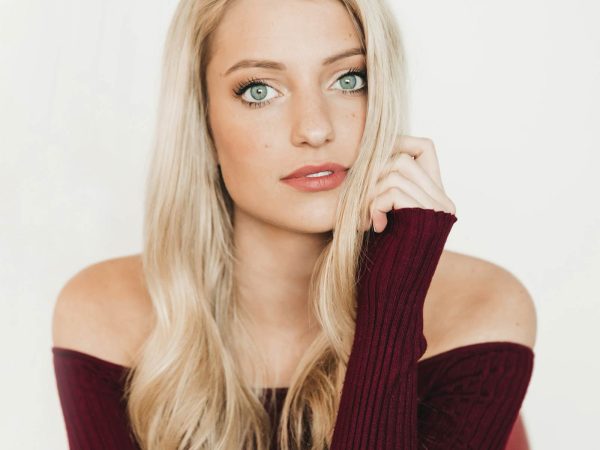 wearing an off-the-shoulder burgundy top