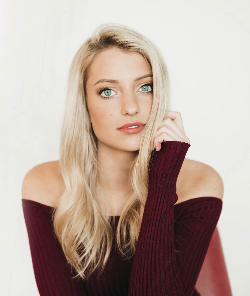 wearing an off-the-shoulder burgundy top