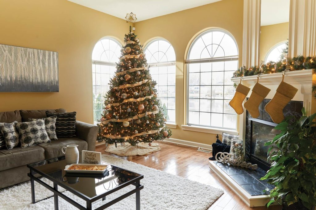 adorned with garland. A gray couch with patterned cushions and a glass coffee table complete the festive setting.|A dining room with a dark wooden table set for six