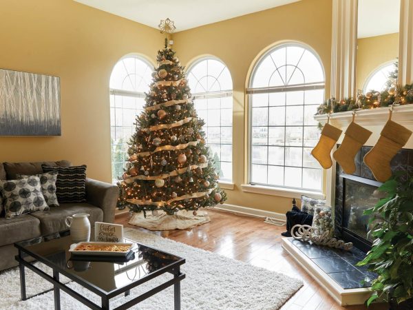 adorned with garland. A gray couch with patterned cushions and a glass coffee table complete the festive setting.|A dining room with a dark wooden table set for six