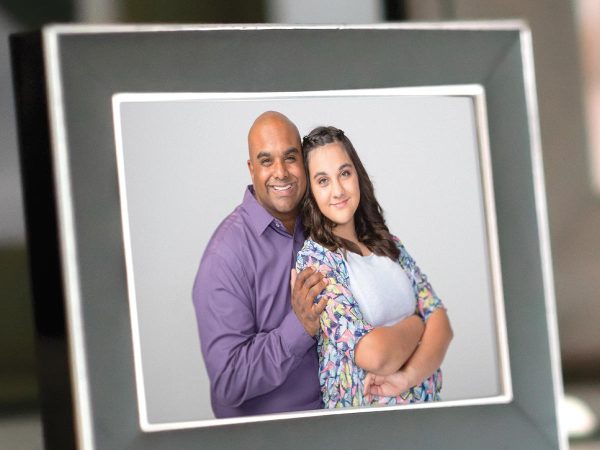 standing in front of a neutral background. They both appear happy.|A man and a woman strike playful poses