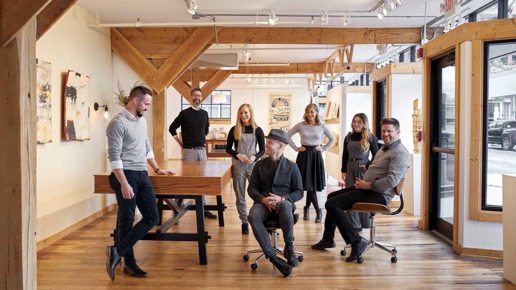 bright office space with wooden beams and large windows. Most are standing