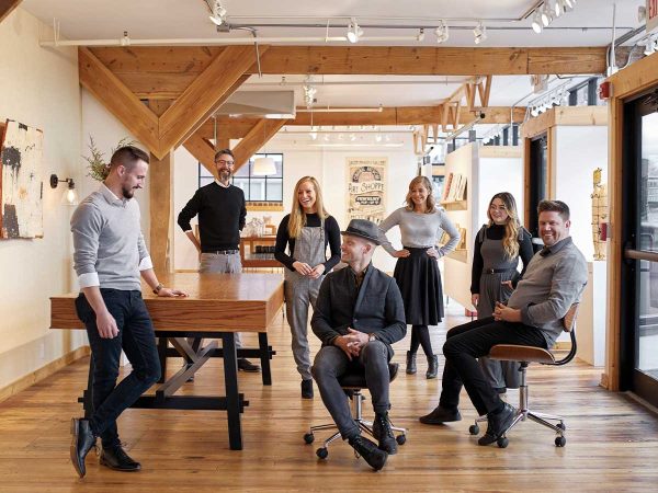 bright office space with wooden beams and large windows. Most are standing