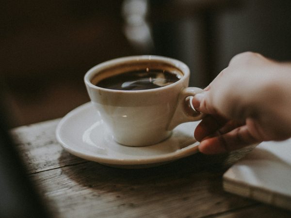 A hand serving coffee