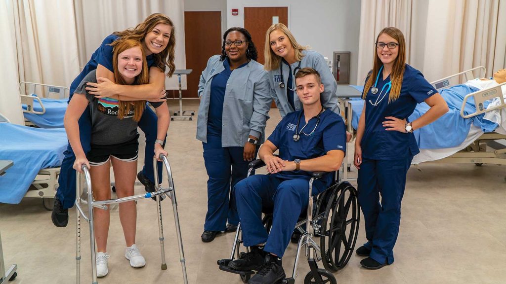 one man in scrubs seated in a wheelchair