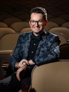 Trent Rash poses for a photograph while seated in the historic Missouri Theatre in Columbia, Missouri.