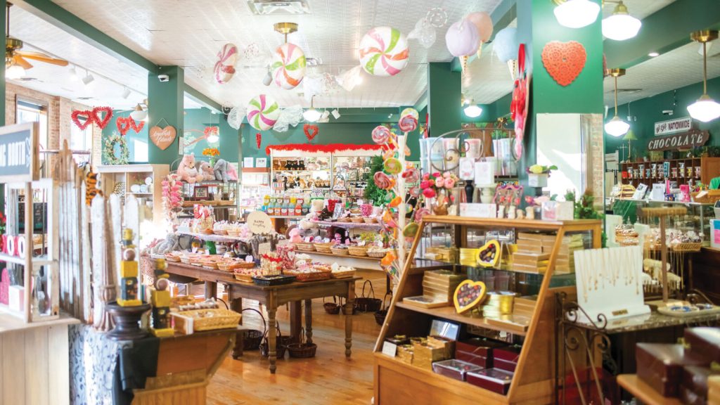 Interior shot of The Candy Factory, showcasing shelves and stacks of colorful candy throughout the store.